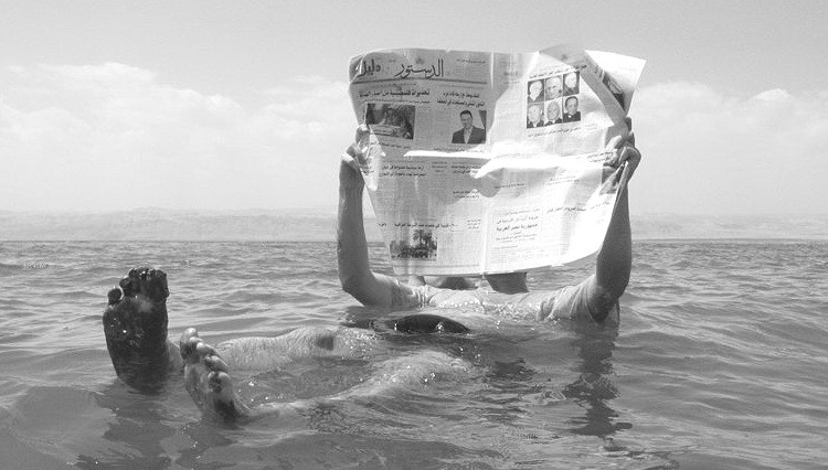 Otkinuta stranica istorije - čitanje novina u vodi Mrtvo more