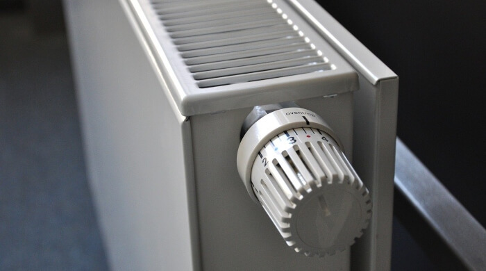 Fotografija belog radijatora za grejanje u sobi